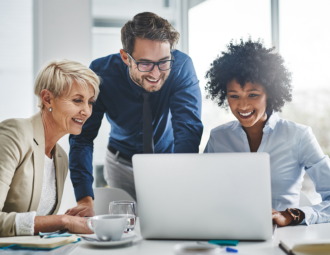 two-women-and-one-man-smiling-looking-at-laptop-screen